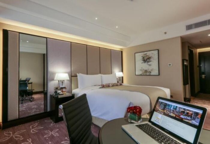 Diamond Hotel room: Laptop on desk, king bed, workspace, and modern decor. Gay-friendly hotel for gay men travel advice and booking.