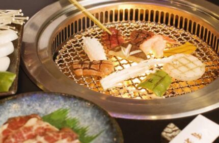 Diamond Hotel: BBQ grill with meat, seafood, and vegetables. Gay-friendly hotel dining experience. Close-up of delicious food.