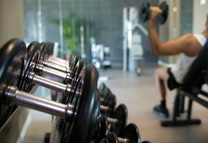 Dolce by Wyndham Sitges gym. Gay-friendly hotel fitness center with weights and a man working out. A great amenity for gay travelers.