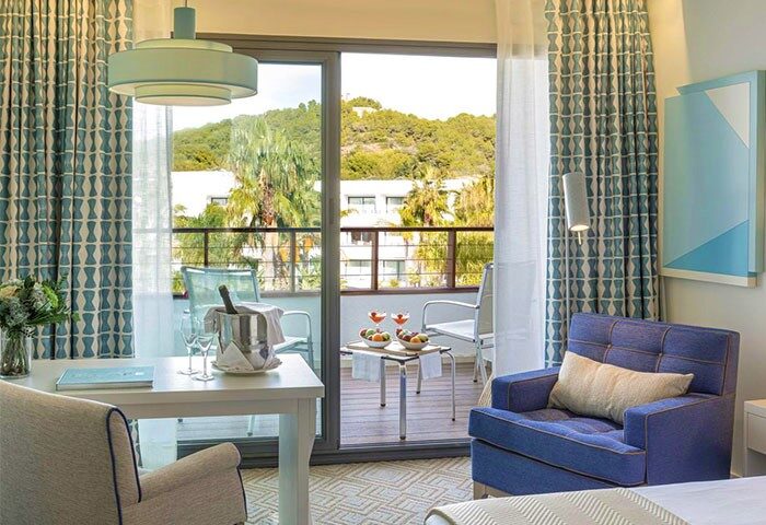 Dolce by Wyndham Sitges hotel room with balcony. Gay-friendly hotel with cocktails, champagne, and fruit. Perfect for gay travel in Sitges.