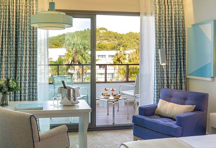 Dolce by Wyndham Sitges hotel room with balcony. Gay-friendly hotel with cocktails, champagne, and fruit. Perfect for gay travel in Sitges.