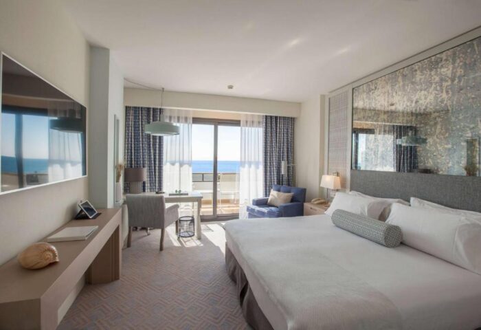 Gay-Friendly Dolce by Wyndham Sitges hotel room. Balcony view. Modern design. Comfortable bed. Ideal for gay travel.