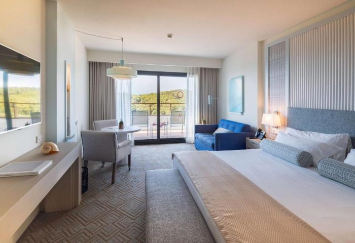 Dolce by Wyndham Sitges gay-friendly hotel room. Balcony view, sofa, and bed. Upscale gay travel accommodations in Sitges, Spain.