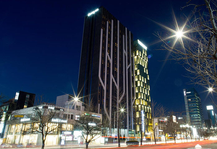 Dormy Inn Premium Seoul Garosugil at night. Gay-friendly hotel with modern architecture. A great choice for gay travel in Seoul, South Korea.