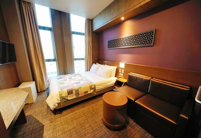 Dormy Inn Premium Seoul Garosugil hotel room. Gay-friendly hotel with bed, sofa, and modern decor. Ideal for gay travelers in Seoul.