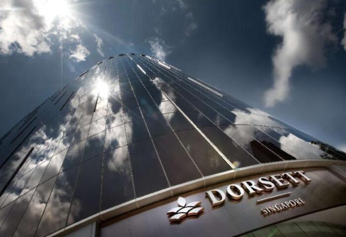 Facade of the gay-friendly Dorsett Singapore hotel reflecting the sky. Modern architecture, luxury destination for gay travelers.