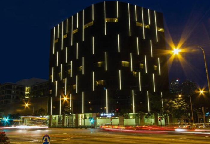 Dorsett Singapore hotel exterior at night. Modern building with vertical light strips. Gay-friendly hotel in Singapore for gay men travel.