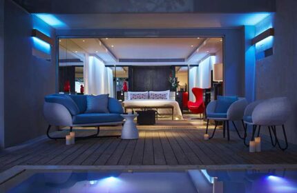 Double-Six Luxury Hotel Seminyak gay-friendly suite. Modern design, blue lighting, outdoor pool, and stylish furniture. Ideal for gay travel.