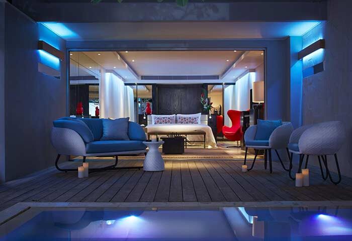 Double-Six Luxury Hotel Seminyak gay-friendly suite. Modern design, blue lighting, outdoor pool, and stylish furniture. Ideal for gay travel.
