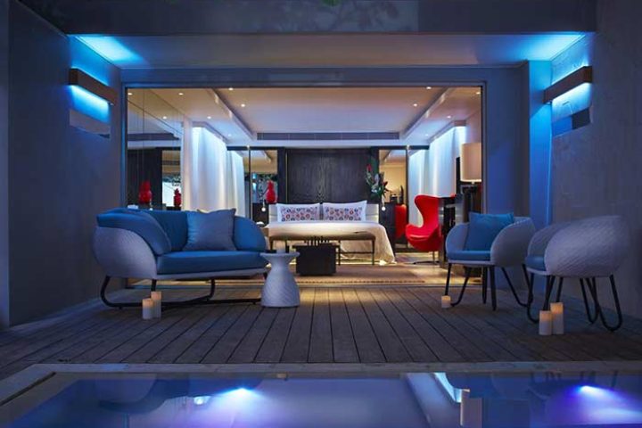 Double-Six Luxury Hotel Seminyak gay-friendly suite. Modern design, blue lighting, outdoor pool, and stylish furniture. Ideal for gay travel.