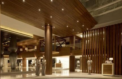 Double-Six Luxury Hotel Seminyak lobby. Gay-friendly hotel with wood design, staff at reception. Upscale, modern interior. Bali travel.