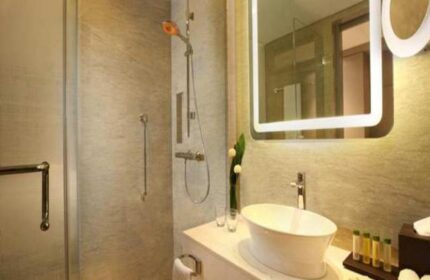 Bathroom at DoubleTree by Hilton Hotel Jakarta Diponegoro. Modern design with shower, sink, and illuminated mirror. Gay-friendly hotel in Jakarta.