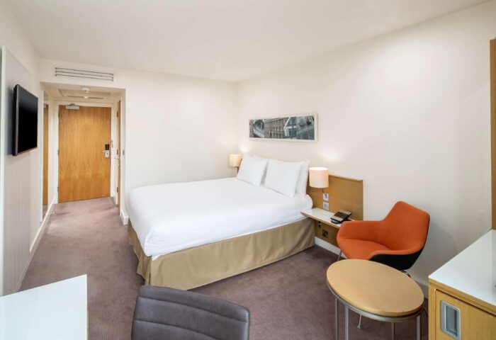 DoubleTree by Hilton Hotel Manchester Piccadilly room. Gay-friendly hotel with bed, chair, and desk. Modern interior, comfortable stay.