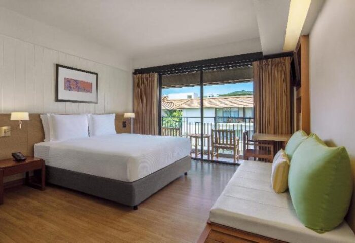 DoubleTree by Hilton Phuket Banthai Resort room. Gay-friendly hotel bedroom with balcony. King bed and daybed. Phuket, Thailand.