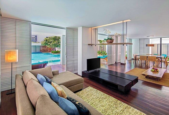 DoubleTree by Hilton Phuket Banthai Resort suite. Living area with pool view. Gay-friendly hotel in Phuket, Thailand. Modern interior.