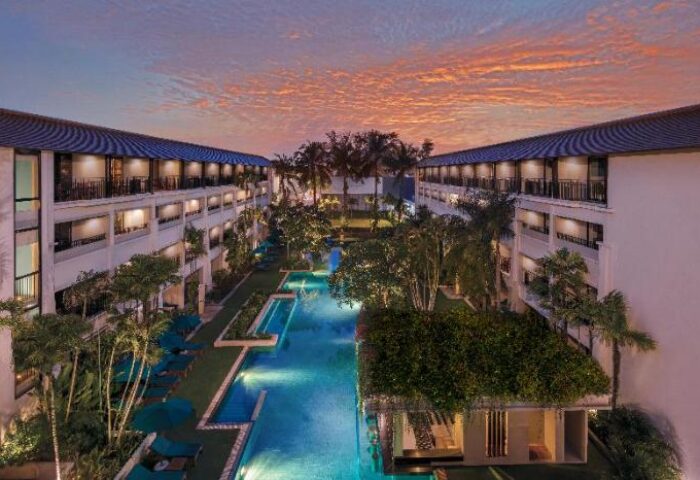 DoubleTree by Hilton Phuket Banthai Resort aerial view at dusk. Gay-friendly hotel with pools, palms, and balconies. Thailand vacation.