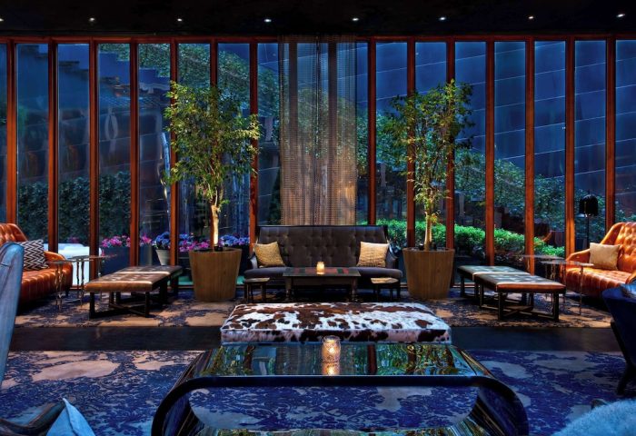 Dream Downtown Hotel's stylish lounge. Gay-friendly hotel with chic decor, sofas, tables, and plants. Perfect for gay men's travel.