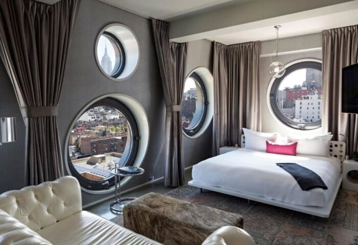 Dream Downtown Hotel room. Gay-friendly hotel with round windows, city views, bed, and couch. Great for gay men's travel.
