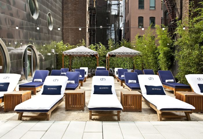 Dream Downtown Hotel's outdoor lounge area. Gay-friendly hotel with stylish loungers, cabanas, and a relaxed vibe. Perfect for gay travelers.