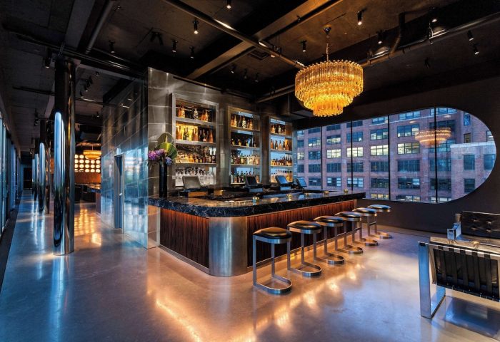 Dream Downtown Hotel bar area. Gay-friendly hotel with a stylish bar, stools, and city view. Upscale ambiance for gay travelers.
