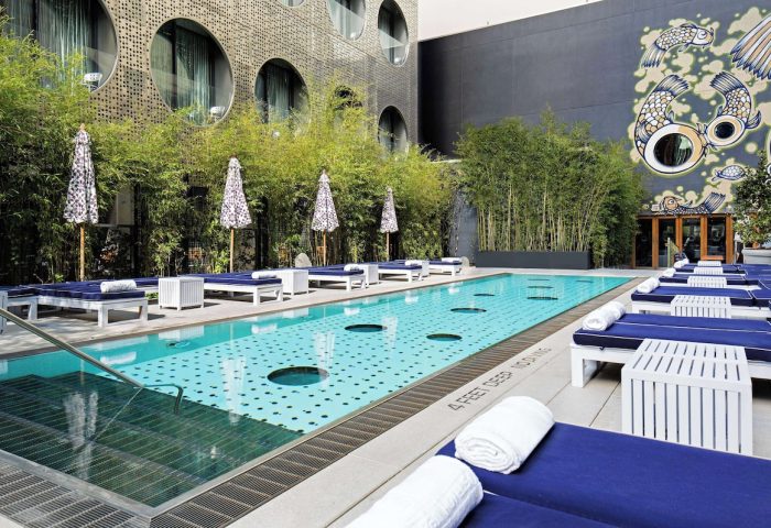 Dream Downtown Hotel pool area. Gay-friendly hotel with stylish sun loungers, umbrellas, and a unique pool design for a luxurious experience.