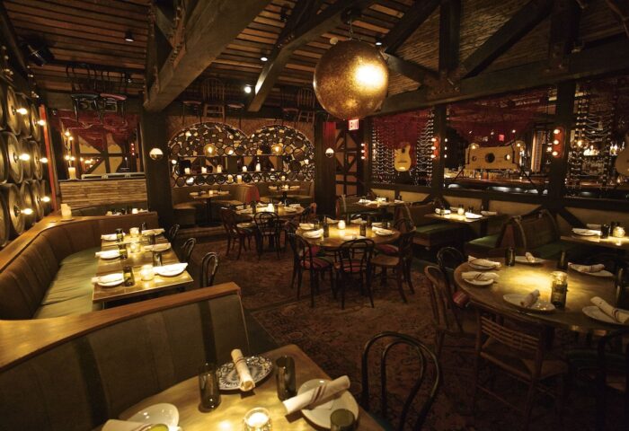 Dream Downtown Hotel's gay-friendly restaurant. Rustic interior with barrel accents, warm lighting, and cozy booths. Fine dining experience.