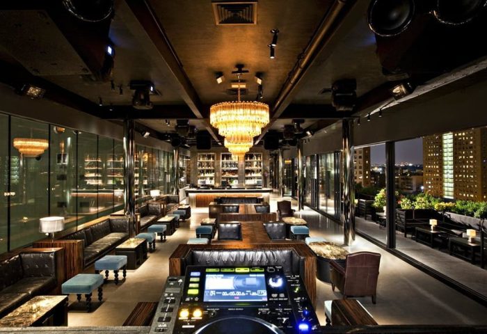 Dream Downtown Hotel's gay-friendly bar. Luxurious interior with a chandelier, DJ booth, and city views. A top gay travel destination.