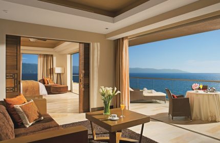 Dreams Vallarta Bay Resort & Spa All Inclusive suite. Gay-friendly hotel room with balcony, ocean view, bed, and living area.
