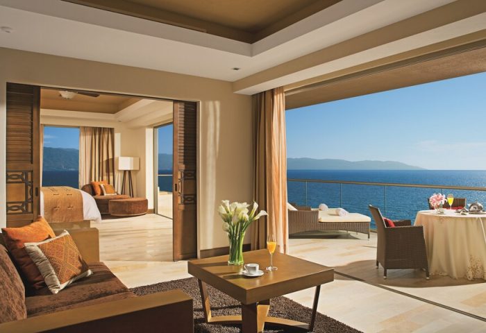 Dreams Vallarta Bay Resort & Spa All Inclusive suite. Gay-friendly hotel room with balcony, ocean view, bed, and living area.