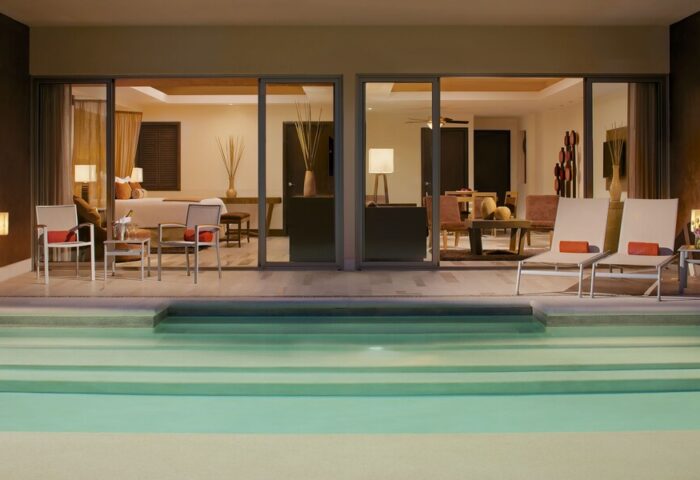 Dreams Vallarta Bay Resort & Spa all-inclusive gay-friendly hotel suite. Poolside view of a luxurious room with chairs and lounge area.