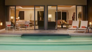 Dreams Vallarta Bay Resort & Spa all-inclusive gay-friendly hotel suite. Poolside view of a luxurious room with chairs and lounge area.