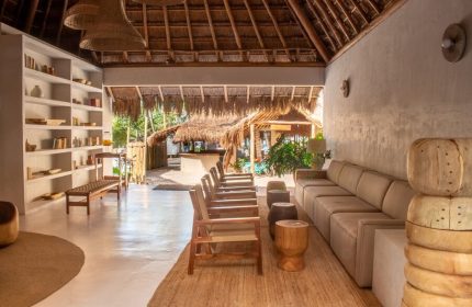 Dune Boutique Hotel lobby at the party zone. Gay-friendly hotel with rustic design, thatched roof, and beach view. Perfect for gay men's travel.