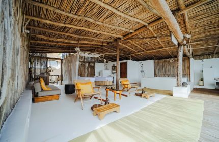 Dune Boutique Hotel's gay-friendly suite in the party zone. Open-air design with thatched roof, lounge chairs, and spa area. Relaxing Tulum vibe.
