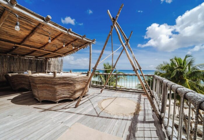 Dune Boutique Hotel's rooftop terrace in the party zone. Gay-friendly hotel with ocean view, wooden furniture, and chill vibe. Perfect for gay travel.