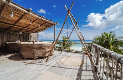 Dune Boutique Hotel's rooftop terrace in the party zone. Gay-friendly hotel with ocean view, wooden furniture, and chill vibe. Perfect for gay travel.