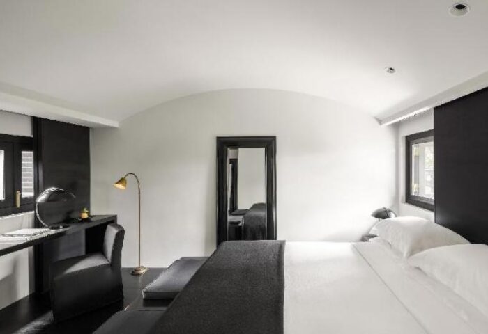 Duxton Reserve Singapore Autograph Collection gay-friendly hotel room. Stylish black and white decor, bed, desk, and mirror.