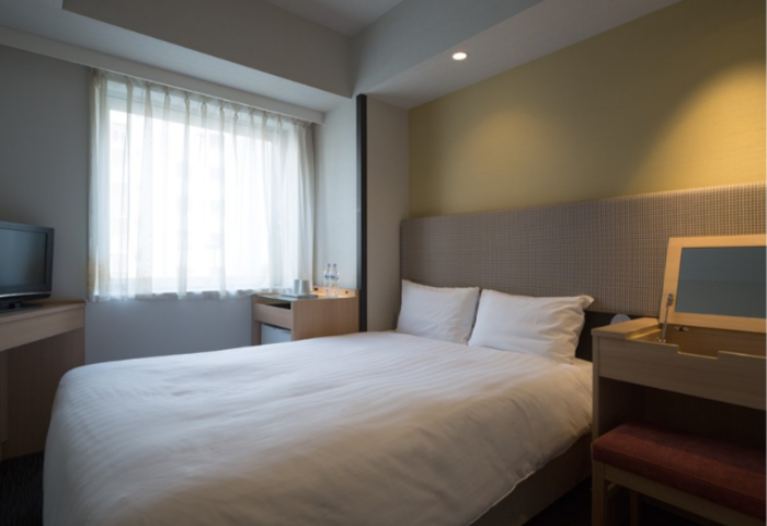 E-Hotel Higashi Shinjuku Tokyo room. Gay-friendly hotel with bed, desk, tv, and window. Ideal for gay travelers visiting Shinjuku, Japan.