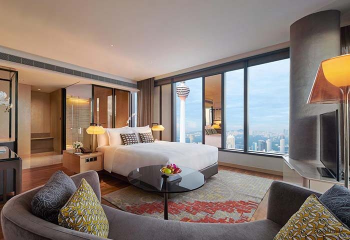 EQ Kuala Lumpur gay-friendly hotel room. View of KL Tower, bed, and city skyline. Modern interior design. Luxury accommodation.