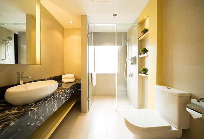 Eco Tree Hotel gay-friendly bathroom. Modern design with marble countertop, sleek sink, glass shower, and toilet. Ideal for gay men travel.