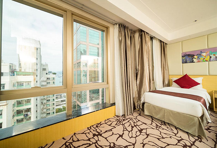 Eco Tree Hotel room. Gay-friendly hotel with city view from large windows. Modern design, single bed, red pillow. Great for gay travel.