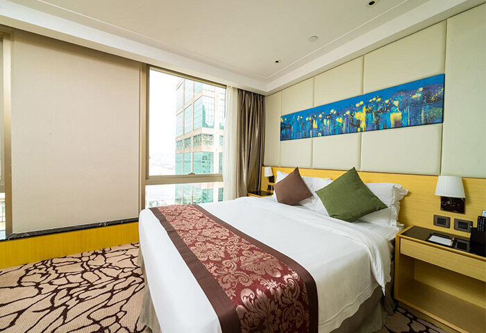 Eco Tree Hotel's gay-friendly room: bed with patterned runner, city view. A modern, comfortable space for gay travelers.
