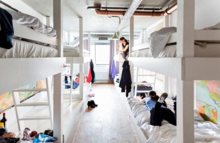 Ecomama Hotel gay-friendly hostel dorm. Bunk beds in a shared room. Travelers relaxing. Budget-friendly accommodation for gay men travel.