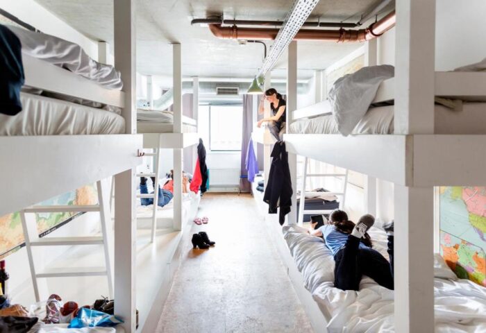 Ecomama Hotel gay-friendly hostel dorm. Bunk beds in a shared room. Travelers relaxing. Budget-friendly accommodation for gay men travel.
