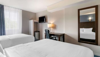 Econo Lodge gay-friendly hotel room with two beds, desk, mini fridge, and TV. Comfortable stay for gay men travelers.