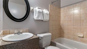 Econo Lodge gay-friendly hotel bathroom. Sink, mirror, towels, toilet, and tiled shower/bathtub combo. Gay travel lodging option.