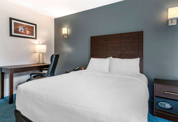 Econo Lodge gay-friendly hotel room interior. Bed, desk, chair, and nightstand with safe. Comfortable lodging for gay travelers.