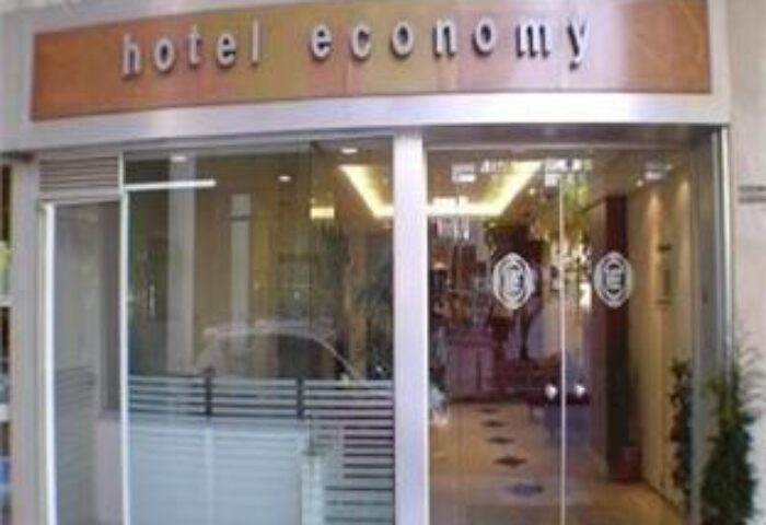 Entrance to a gay-friendly Economy Hotel. Glass doors with horizontal stripes. Sign reads hotel economy. Great for gay travel on a budget.