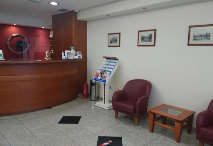 Lobby area of a gay-friendly economy hotel. Reception desk, seating area, and tourist information. Welcoming space for gay travelers.
