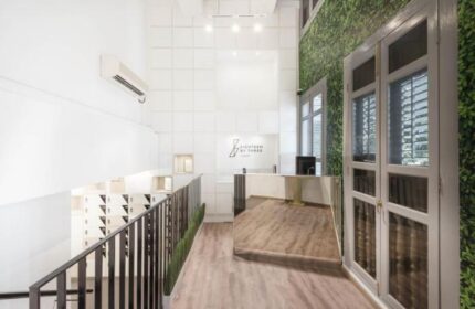 Eighteen By Three Cabins' lobby. This gay-friendly hotel features a modern design with white walls, wood floors, and a green wall. Great for gay travel.