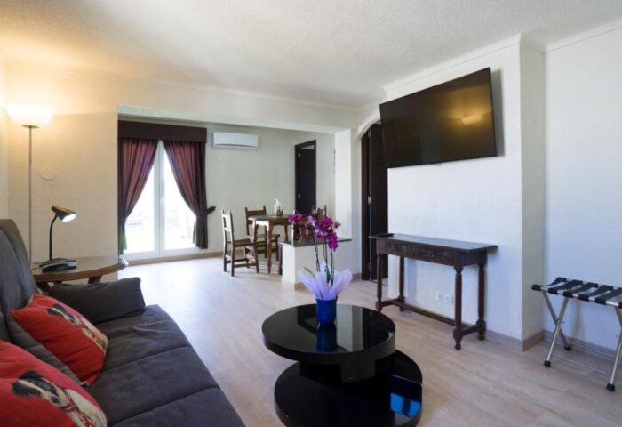 El Pozo gay-friendly hotel room. Living area with sofa, TV, and table. Modern design, comfortable for gay travelers. #GayTravel #GayHotel